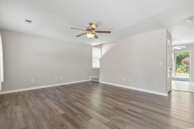 unfurnished living room featuring visible vents, baseboards, ceiling fan, and wood finished floors