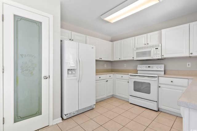 kitchen with light countertops, white cabinetry, light tile patterned flooring, and white appliances