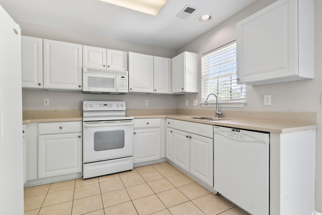 kitchen with a sink, light countertops, white cabinets, and white appliances