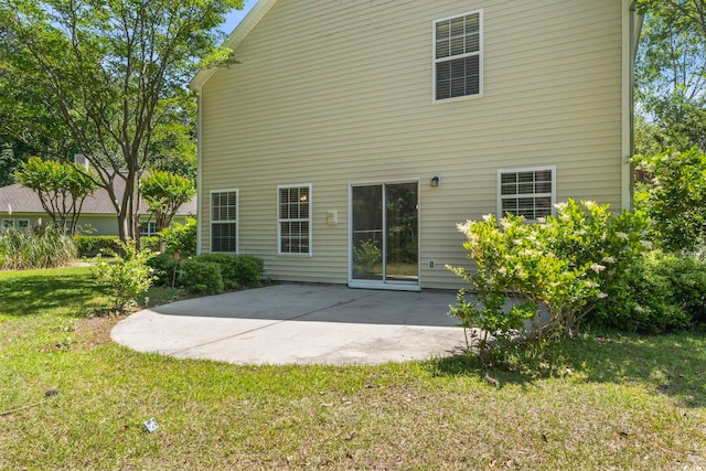back of property featuring a lawn and a patio