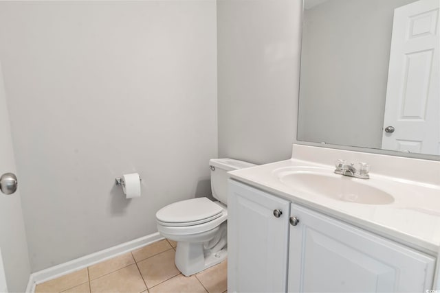 bathroom with baseboards, tile patterned floors, toilet, and vanity