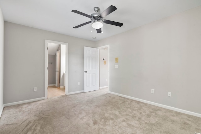unfurnished bedroom with baseboards, ensuite bathroom, carpet, and ceiling fan