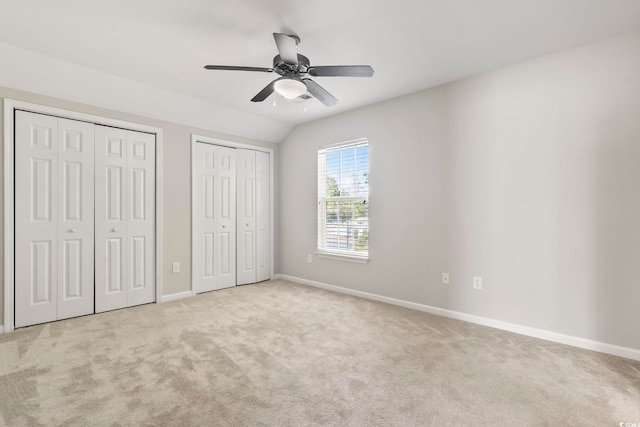 unfurnished bedroom featuring carpet flooring, baseboards, and multiple closets