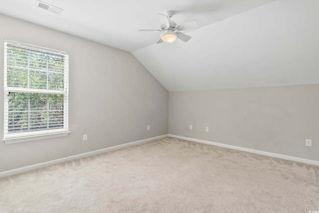 additional living space featuring baseboards, lofted ceiling, light colored carpet, and visible vents