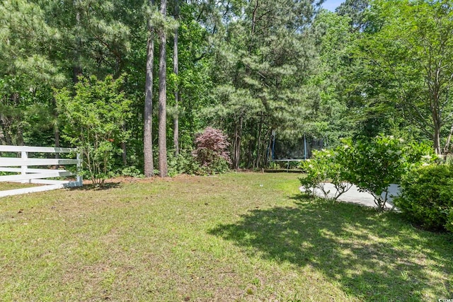 view of yard featuring fence and a trampoline