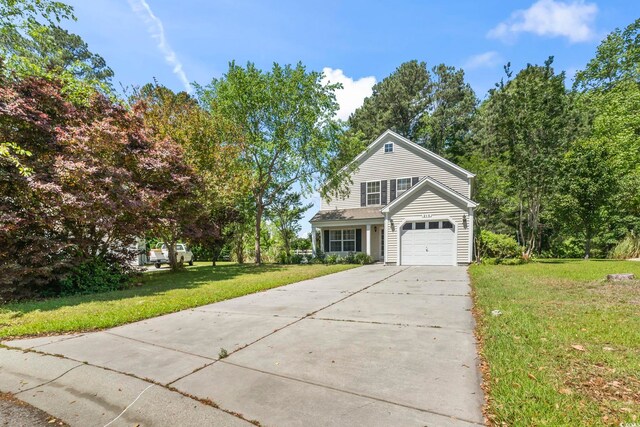 traditional-style home featuring a garage, driveway, and a front yard