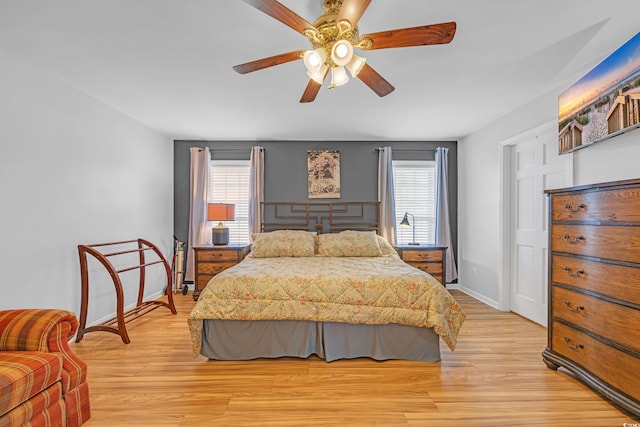 bedroom with multiple windows, light wood-style flooring, and ceiling fan