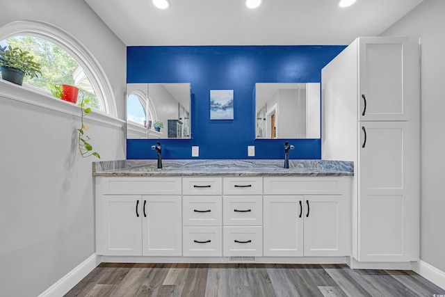 full bath with wood finished floors, baseboards, a sink, and recessed lighting