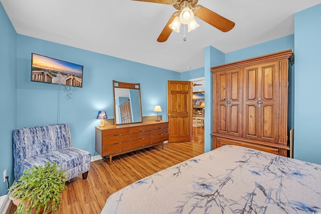 bedroom with baseboards, ceiling fan, and wood finished floors