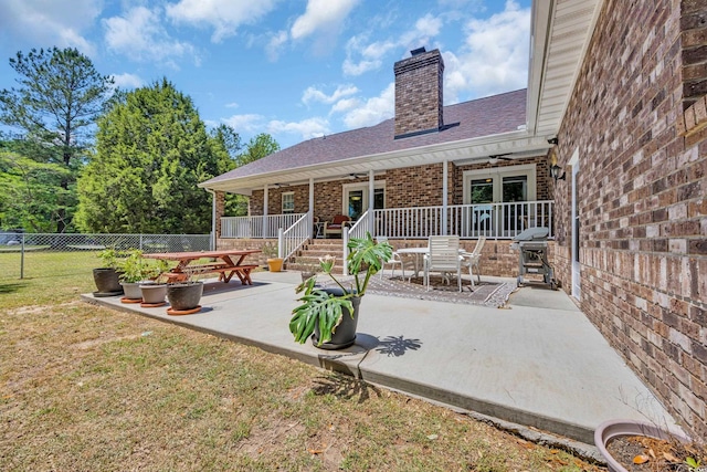 back of house featuring a patio, a ceiling fan, a chimney, fence, and a yard