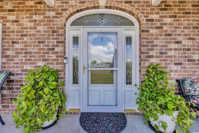 view of exterior entry with brick siding