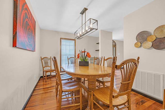 dining area with an inviting chandelier, visible vents, and light wood-style floors