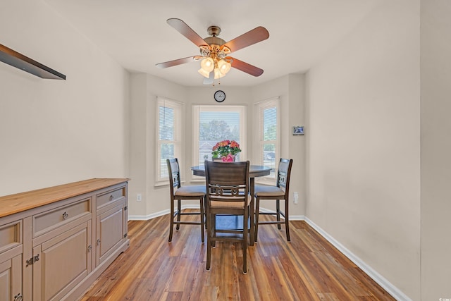 dining room with baseboards, ceiling fan, and light wood-type flooring