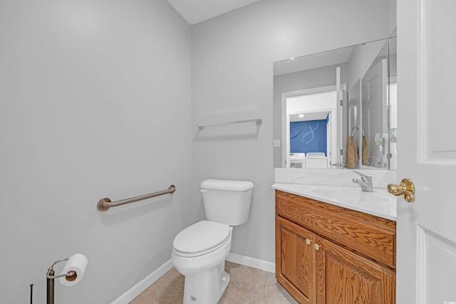 half bathroom featuring tile patterned floors, toilet, baseboards, and vanity