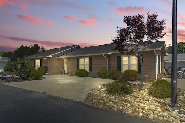 ranch-style home with roof with shingles