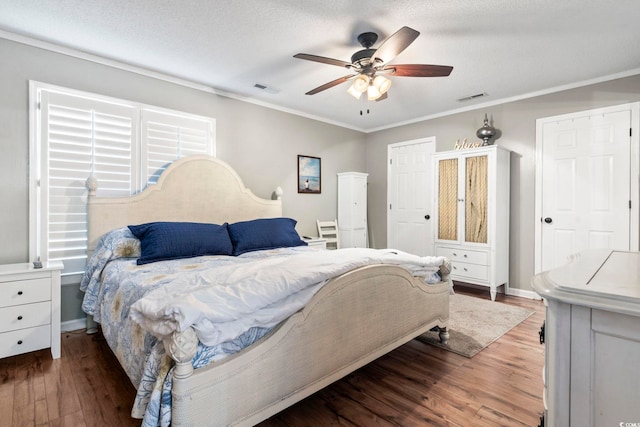 bedroom featuring crown molding, visible vents, and wood finished floors