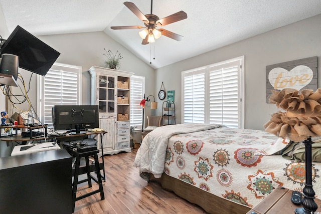 bedroom with a ceiling fan, vaulted ceiling, and light wood-type flooring
