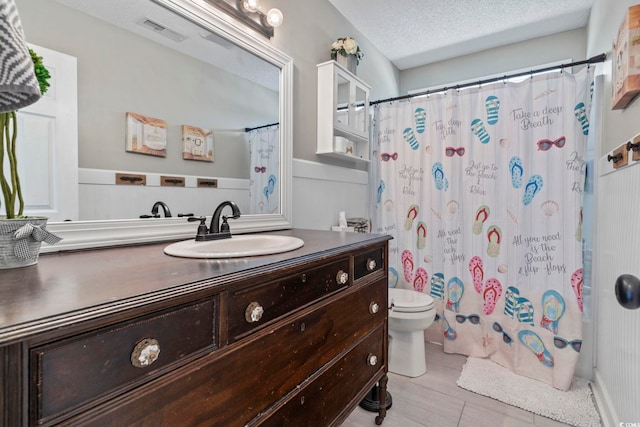 bathroom featuring a textured ceiling, visible vents, vanity, toilet, and a shower with shower curtain