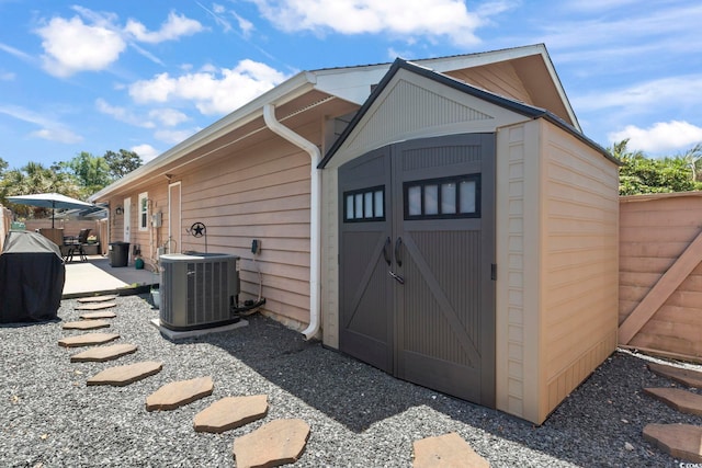 view of shed featuring fence and cooling unit