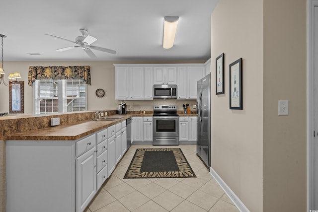 215-B S Dogwood Dr, Surfside Beach, SC 29575 - kitchen featuring a peninsula, light tile patterned flooring, dark countertops, a sink, and appliances with stainless steel finishes