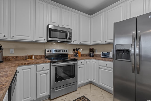 215-B S Dogwood Dr, Surfside Beach, SC 29575 - kitchen featuring white cabinets, appliances with stainless steel finishes, light tile patterned flooring, and dark countertops