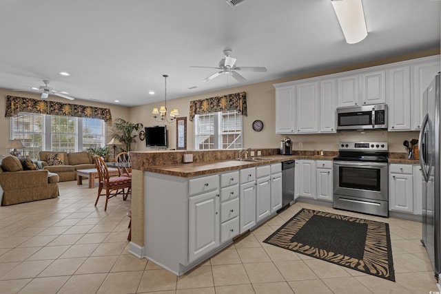 215-B S Dogwood Dr, Surfside Beach, SC 29575 - kitchen with a peninsula, ceiling fan with notable chandelier, dark countertops, and stainless steel appliances