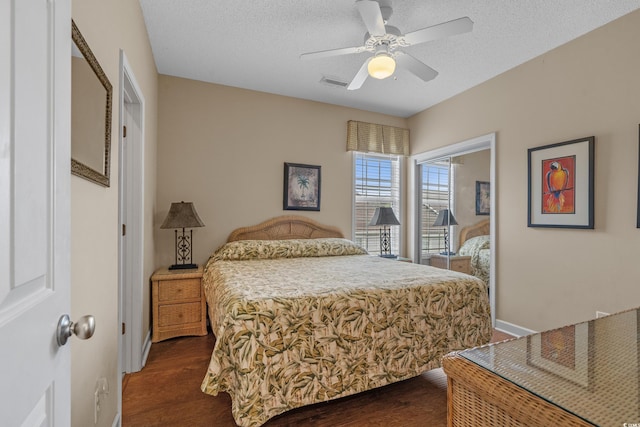 215-B S Dogwood Dr, Surfside Beach, SC 29575 - bedroom with a ceiling fan, dark wood-style flooring, a textured ceiling, visible vents, and baseboards