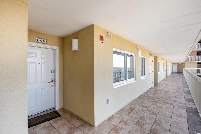 entrance to property featuring stucco siding and a balcony