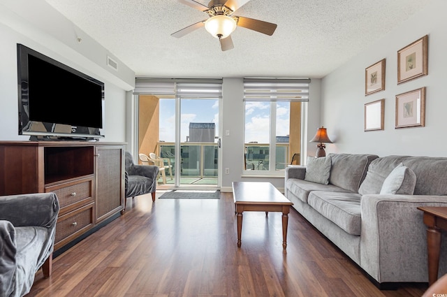 living room with ceiling fan, dark wood-style flooring, a textured ceiling, and visible vents