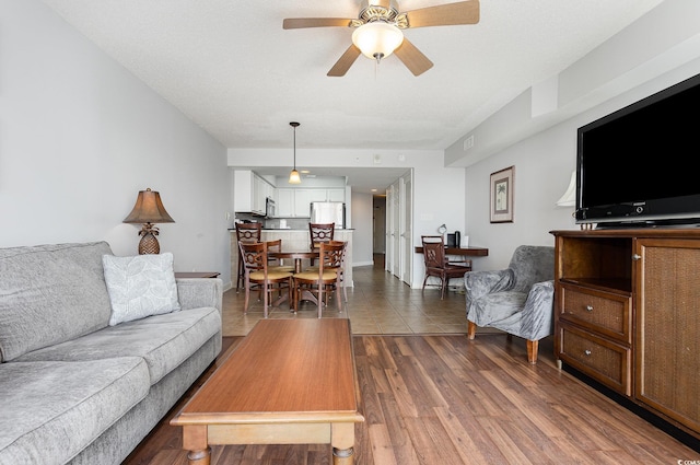 living room with ceiling fan and dark wood-style floors