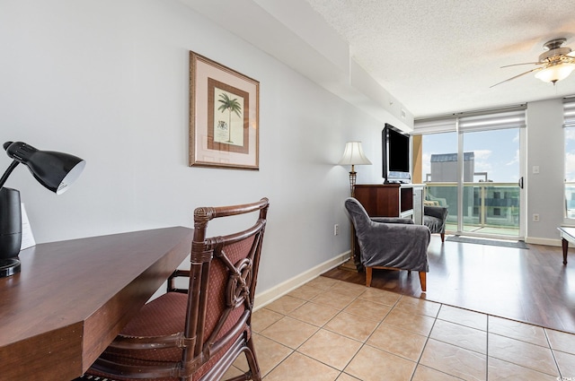 home office with baseboards, a ceiling fan, a textured ceiling, and light tile patterned floors