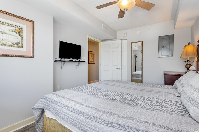 bedroom with ceiling fan, electric panel, visible vents, baseboards, and dark wood-type flooring
