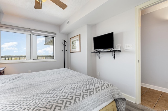 bedroom with baseboards, a ceiling fan, and visible vents