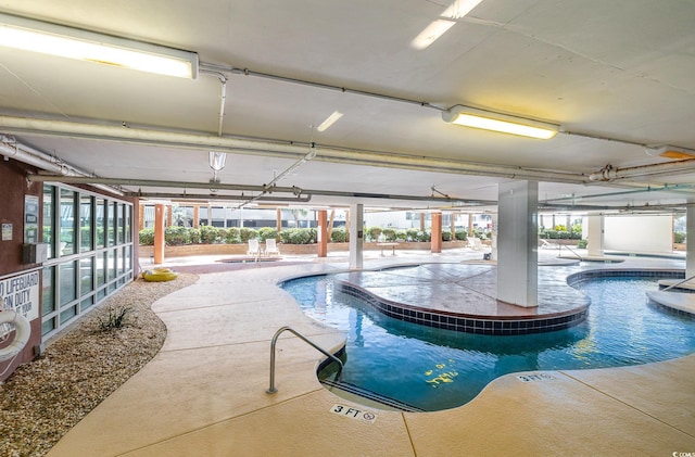 community pool with a patio and an indoor in ground hot tub