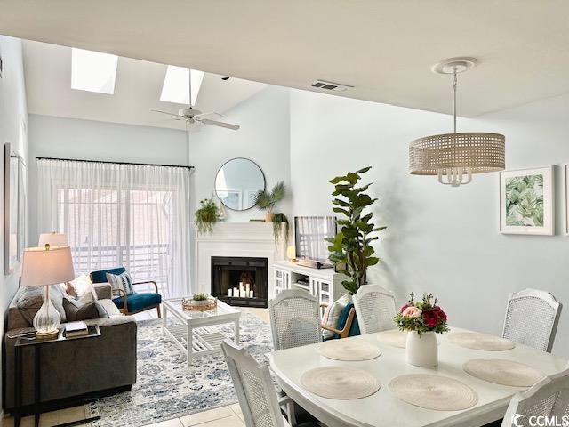 201 N Hillside Dr Unit 311-A, North Myrtle Beach, SC 29582 - dining area with visible vents, a skylight, tile patterned flooring, a fireplace, and ceiling fan with notable chandelier