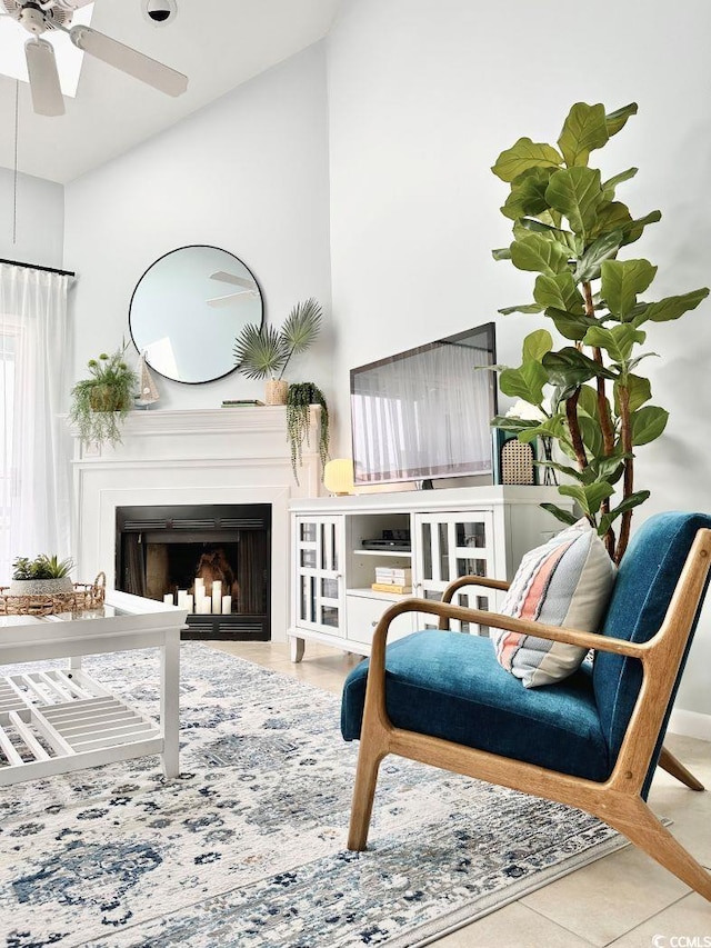 sitting room featuring ceiling fan, vaulted ceiling, and a fireplace