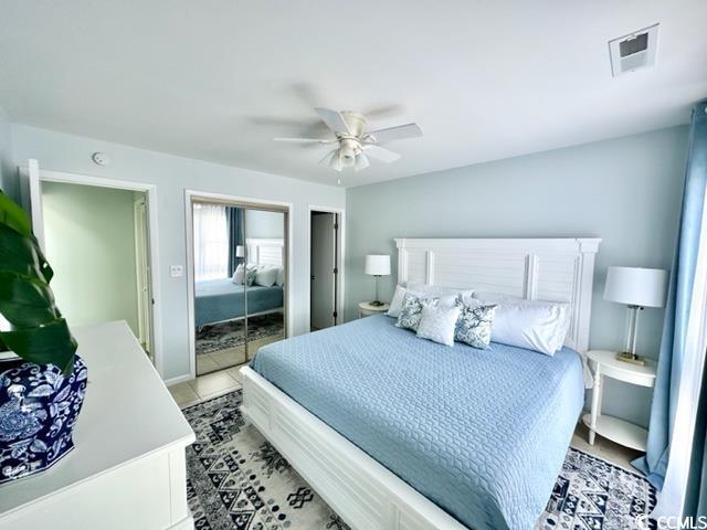 bedroom with ceiling fan, two closets, and visible vents