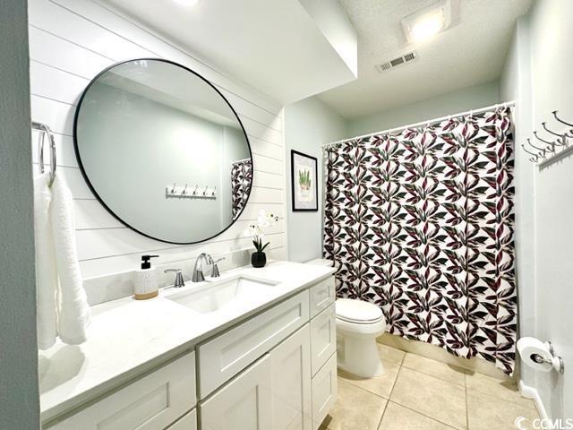 bathroom with toilet, visible vents, tile patterned flooring, and vanity