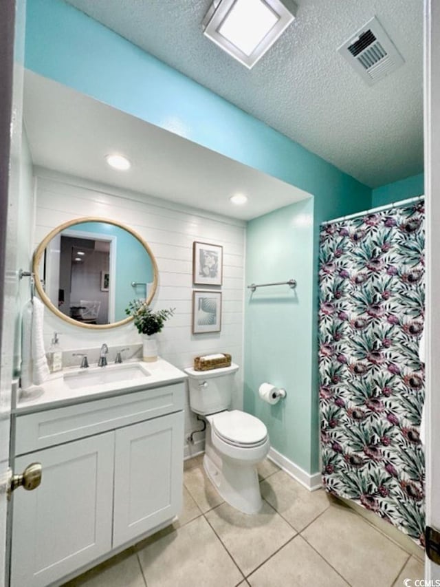 full bathroom with tile patterned flooring, vanity, toilet, a textured ceiling, and visible vents