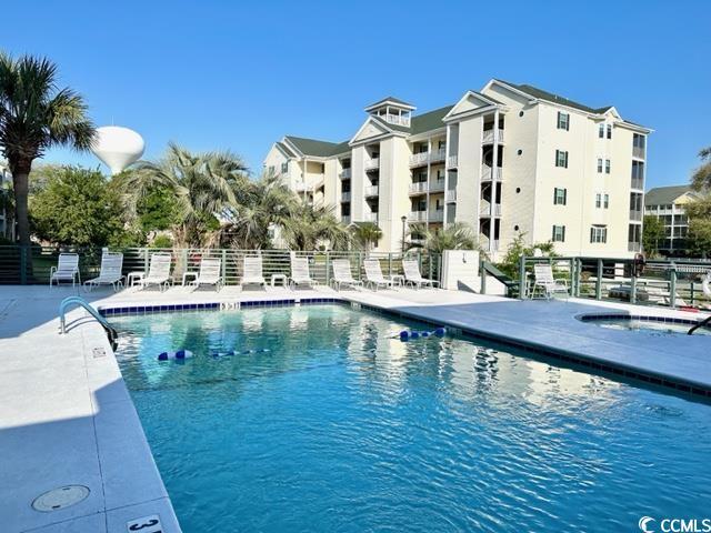 community pool featuring fence, a community hot tub, and a patio area
