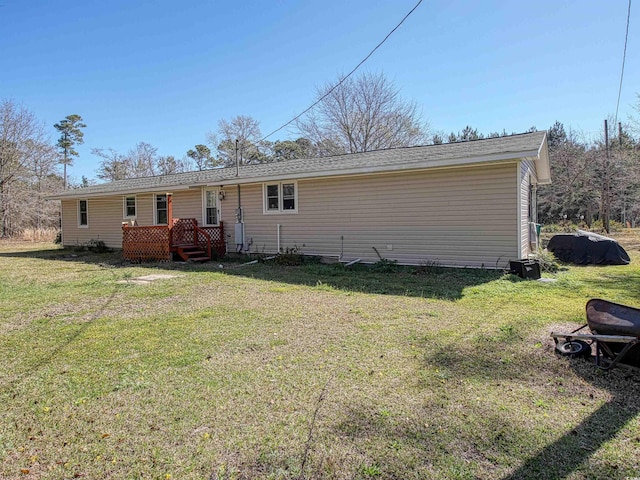 back of property with a yard and a deck