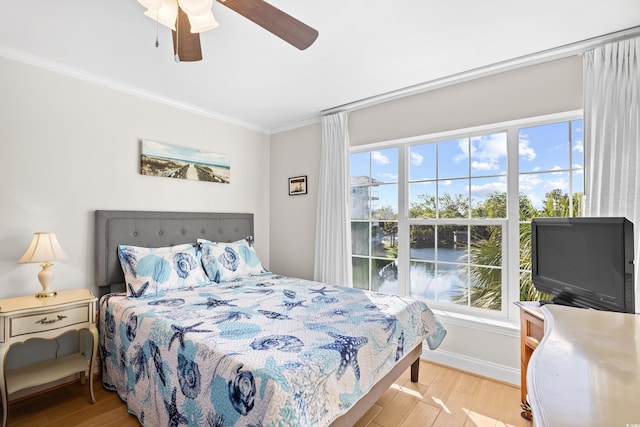 bedroom with ceiling fan, ornamental molding, and light wood finished floors