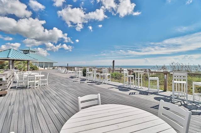 wooden terrace with outdoor dining area and a water view