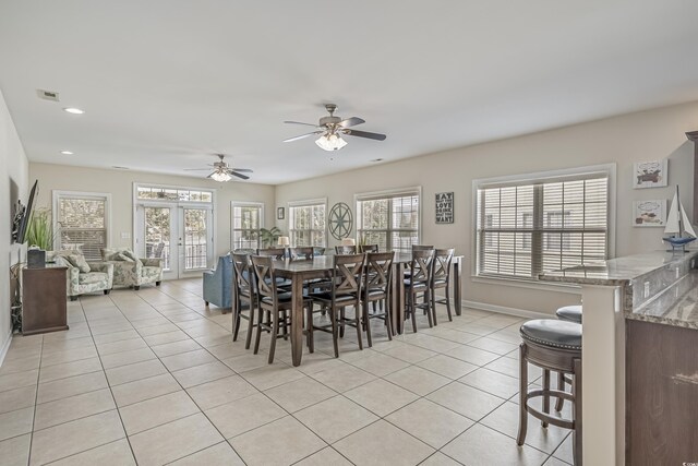 dining area with a healthy amount of sunlight, baseboards, light tile patterned flooring, and visible vents