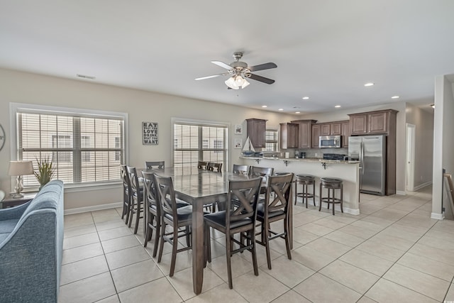 dining room with light tile patterned floors, baseboards, ceiling fan, and plenty of natural light