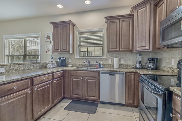kitchen featuring plenty of natural light, stainless steel appliances, and light tile patterned flooring