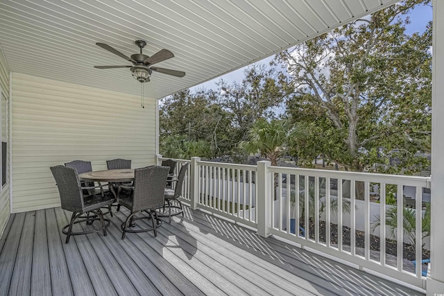 wooden terrace with a ceiling fan and outdoor dining space