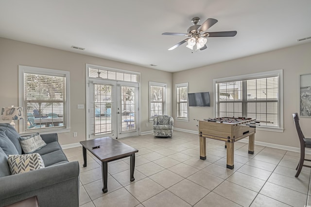 game room with light tile patterned flooring, a ceiling fan, visible vents, and baseboards