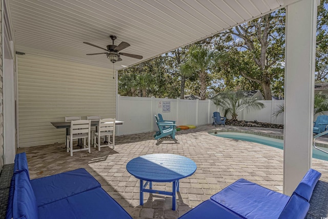 view of patio / terrace with a fenced in pool, a fenced backyard, a ceiling fan, and outdoor dining space