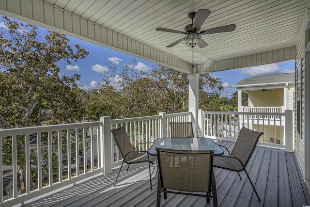 wooden terrace featuring ceiling fan and outdoor dining space